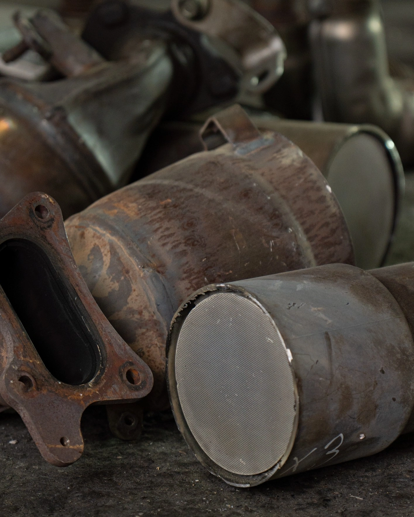 Pile of used catalytic converters with visible honeycomb core