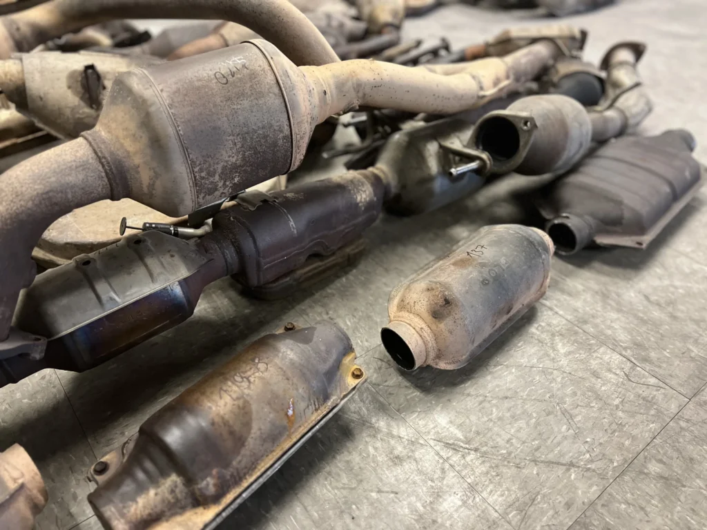 Assorted used catalytic converters on workshop floor